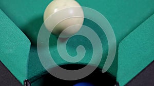 Five billiard ball falling into table hole