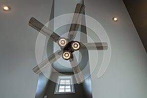 Five blade ceiling fan with three lights hangs over head