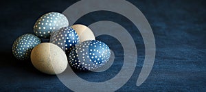 Five Blue And Beige Easter Eggs Decorated With Polka Dot Patterns on Dark Blue Background. photo