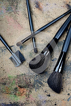 Five brushes on a dingy background