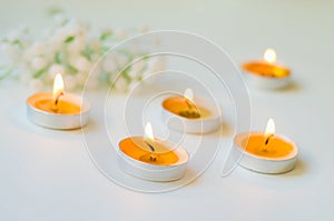 Five burning candles on white background. Relaxation and aromatherapy concept