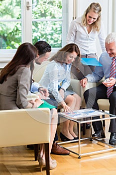 Five business people in team meeting studying graphs