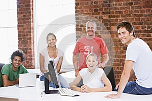 Five businesspeople in office space smiling