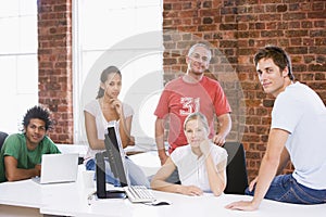 Five businesspeople in office space smiling