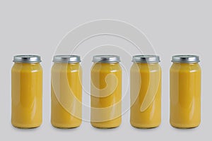 Five cans of canned apple puree in glass jar on gray background