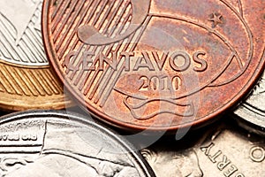 Five Centavos Brazilian Real coin stacked over other coins