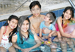 Five children sitting in pool