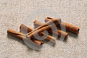 Five cinnamon sticks on a linen fabric background