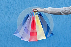 Five colored bags for shopping in a female hand. Close-up. Shopping