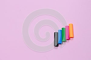 Five colorful pen cap on a pink millennial background. Space to insert the text. Office stuff. Minimalism.