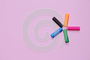 Five colorful pen cap on a pink millennial background. Space to insert the text. Office stuff. Minimalism.