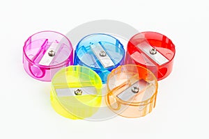 Five colorful plastic pencil sharpeners on white background