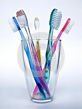 Five toothbrushes on glass