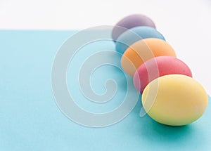Five colourful easter-eggs in a row. Blue and white background