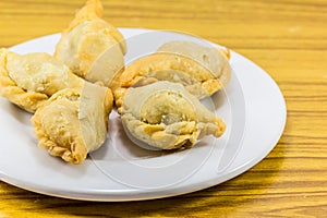 Five curry puffs on white plate