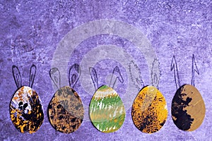 Five decorative colorful paper eggs with drawn bunny ears