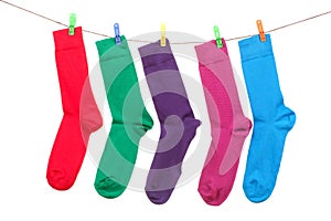 Five different color socks hang on rope