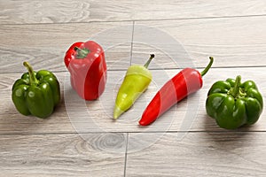 Five different kinds of pepper on a wooden board