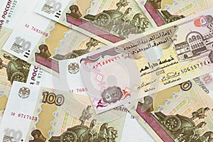 A five dirham bank note from United Arab Emirates on a background of Russian one hundred ruble bank notes.