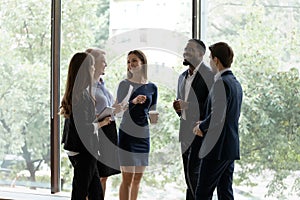 Five diverse office employees take break chatting resting after seminar