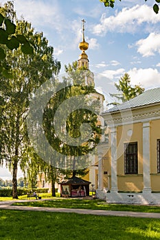 Uglich, Russia, July 9, 2023. The bell tower of the Transfiguration Cathedral behind the trees of the park.