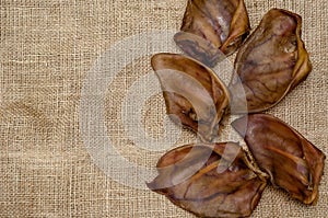 Five dried pork ears on burlap