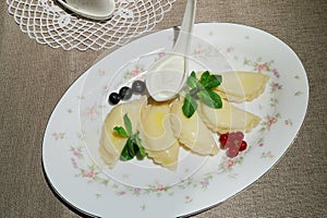 Five dumplings with berries and sour cream on photo
