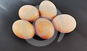 Five eggs on the black background. Eggs for ingridient to