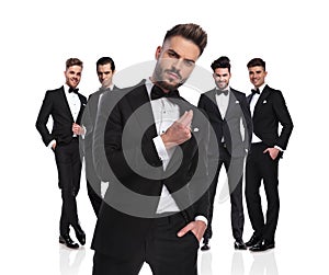 Five elegant groomsmen standing with arrogant leader in front photo