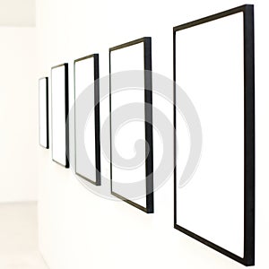 Five empty frames on white wall exhibition