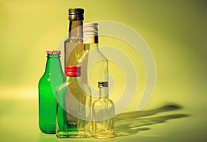 five empty green and transparent glass bottles with caps