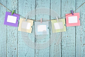 Five empty photo frames hanging with clothespins