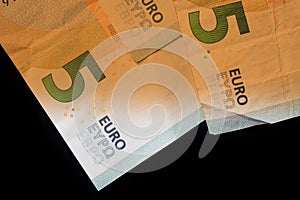 Five euro banknotes on a dark background. Money background brown color toned