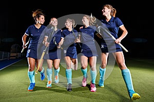 Five field hockey players celebrate the victory