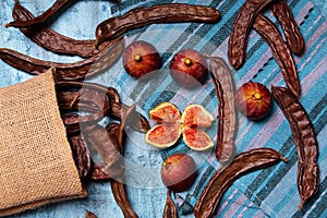 Five figs and carob pods on blue background photo