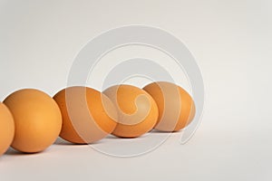Five fresh brown chicken eggs in a row diagonally on grey background. Easter holiday