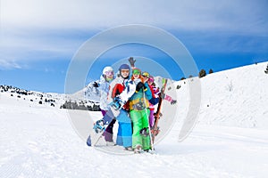 Five friends together with snowboards and skis