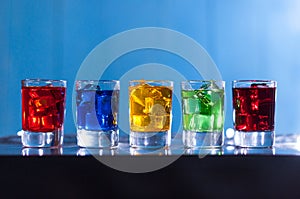 Five glasses with alcohol cocktail on the bar at