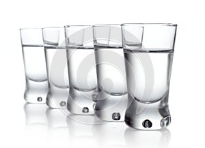 Five glasses of vodka isolated on white