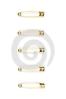 Five gold safety pins stacked on a white background