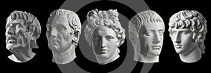 Five gypsum copy of ancient statue heads isolated on a black background. Plaster sculpture mans faces.