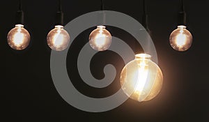 five hanging light bulb on black background. energy
