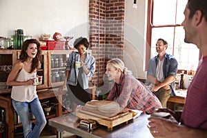 Five happy friends laughing in kitchen, selective focus