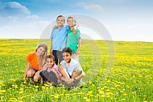 Five happy kids in dandelions
