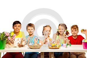 Five happy kids painting Eastern eggs together