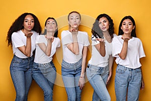 Five Happy Multicultural Women Blowing Kisses To Camera, Yellow Background