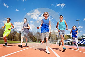 Cinco feliz adolescente correr sobre el estadio 