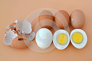 Five hard boiled brown chicken eggs on a brown background