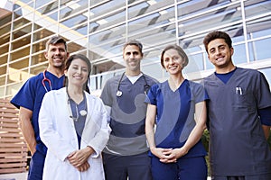 Five healthcare colleagues standing outdoors, group portrait