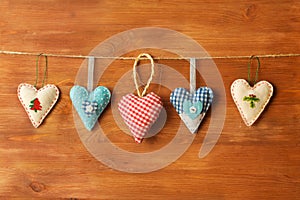 Five hearts made of cloth on wood background